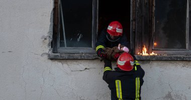 İtfaiyeci kahraman yangından sonra bebeğini yanan binadan dışarı taşıyor. İnsanları tehlikeli bir yerden kurtarmak. Takım çalışması Yüksek kalite fotoğraf