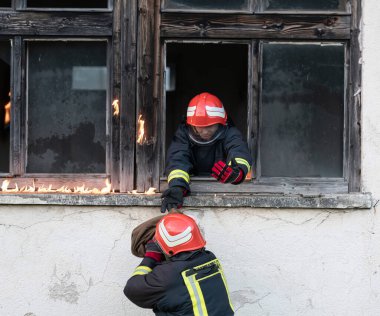 İtfaiyeci kahraman yangından sonra bebeğini yanan binadan dışarı taşıyor. İnsanları tehlikeli bir yerden kurtarmak. Takım çalışması Yüksek kalite fotoğraf