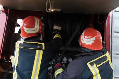 Bir grup itfaiyeci iyi yapılmış bir kurtarma operasyonundan sonra kendinden emin duruyor. İtfaiyeciler acil servise hazır. Yüksek kalite fotoğraf