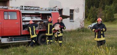 Bir grup itfaiyeci iyi yapılmış bir kurtarma operasyonundan sonra kendinden emin duruyor. İtfaiyeciler acil servise hazır. Yüksek kalite fotoğraf