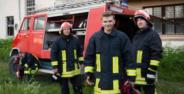 Bir grup itfaiyeci iyi yapılmış bir kurtarma operasyonundan sonra kendinden emin duruyor. İtfaiyeciler acil servise hazır. Yüksek kalite fotoğraf