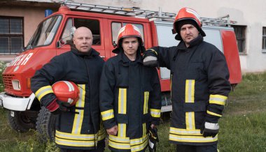 Bir grup itfaiyeci iyi yapılmış bir kurtarma operasyonundan sonra kendinden emin duruyor. İtfaiyeciler acil servise hazır. Yüksek kalite fotoğraf