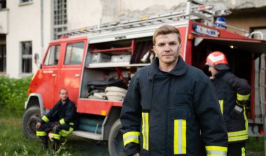 Bir grup itfaiyeci iyi yapılmış bir kurtarma operasyonundan sonra kendinden emin duruyor. İtfaiyeciler acil servise hazır. Yüksek kalite fotoğraf