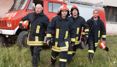 Bir grup itfaiyeci iyi yapılmış bir kurtarma operasyonundan sonra kendinden emin duruyor. İtfaiyeciler acil servise hazır. Yüksek kalite fotoğraf