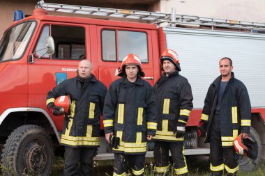 Bir grup itfaiyeci iyi yapılmış bir kurtarma operasyonundan sonra kendinden emin duruyor. İtfaiyeciler acil servise hazır. Yüksek kalite fotoğraf