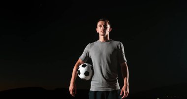 Sokakta futbol topuyla oynayan yakışıklı bir futbolcunun portresi. Yüksek kalite fotoğraf