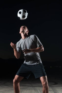Sokakta futbol topuyla oynayan yakışıklı bir futbolcunun portresi. Yüksek kalite fotoğraf