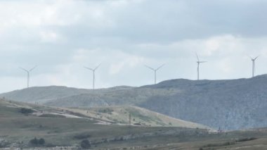 Devasa rüzgar türbini dönüyor. Yenilenebilir enerji, sürdürülebilir kalkınma, çevre dostu kavram. İHA 'dan sinematik hava görüntüsü, 4K. Düzeltilmemiş Yüksek kalite 4K görüntü