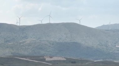 Devasa rüzgar türbini dönüyor. Yenilenebilir enerji, sürdürülebilir kalkınma, çevre dostu kavram. İHA 'dan sinematik hava görüntüsü, 4K. Düzeltilmemiş Yüksek kalite 4K görüntü