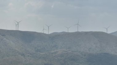 Devasa rüzgar türbini dönüyor. Yenilenebilir enerji, sürdürülebilir kalkınma, çevre dostu kavram. İHA 'dan sinematik hava görüntüsü, 4K. Düzeltilmemiş Yüksek kalite 4K görüntü