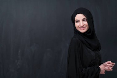 Modern İslam modasını ve Ramazan Kareem kavramını temsil eden siyah karatahtanın önünde tesettürlü şık giyinmiş güzel bir Müslüman kadının portresi. 
