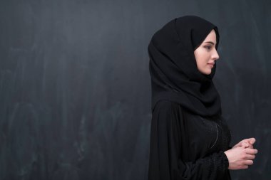 Modern İslam modasını ve Ramazan Kareem kavramını temsil eden siyah karatahtanın önünde tesettürlü şık giyinmiş güzel bir Müslüman kadının portresi. 