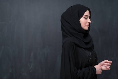 Modern İslam modasını ve Ramazan Kareem kavramını temsil eden siyah karatahtanın önünde tesettürlü şık giyinmiş güzel bir Müslüman kadının portresi. 