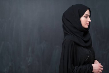 Modern İslam modasını ve Ramazan Kareem kavramını temsil eden siyah karatahtanın önünde tesettürlü şık giyinmiş güzel bir Müslüman kadının portresi. 