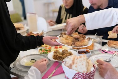 Mübarek Mübarek bayram ailesi ziyafeti kırmak için havan suyu içiyor. Ramazan Bayramı 'nda evde geleneksel yemekler yemek. Modern batı adasındaki İslami Helal Yeme ve İçme