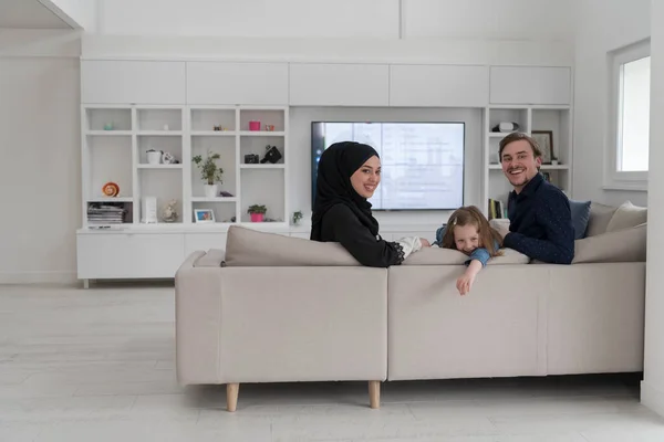 一个快乐的穆斯林家庭 女儿穿着传统的时髦衣服 坐在沙发上玩得开心愉快 高质量的照片 — 图库照片