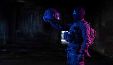 Saldırı tüfeği ve miğfer takan savaş üniformalı asker karanlık bir geçmişi var. Mavi ve mor jel ışık efekti. Yüksek kalite fotoğraf