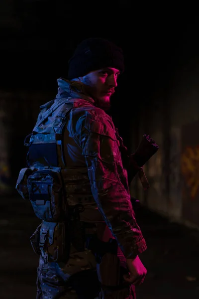 身穿作战制服的陆军士兵 手持冲锋枪 头戴作战头盔 夜间任务背景漆黑 蓝色和紫色的凝胶光效果 高质量的照片 — 图库照片