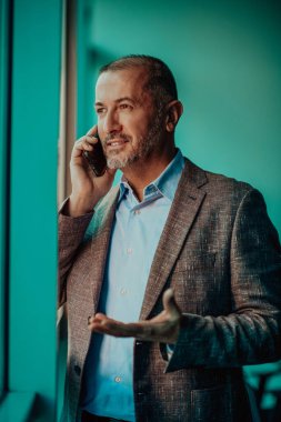 Takım elbiseli modern kıdemli işadamı şehir ortamında akıllı telefon kullanıyor. Yüksek kalite fotoğraf