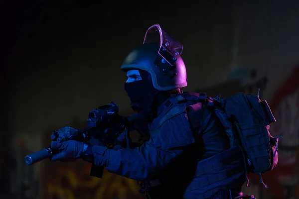 アサルトライフルと戦闘ヘルメットナイトミッション暗い背景を持つコンバットユニフォームの陸軍兵士 青と紫のゲル光効果 高品質の写真 — ストック写真
