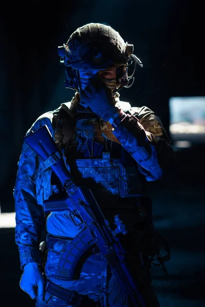 アサルトライフルと戦闘ヘルメットナイトミッション暗い背景を持つコンバットユニフォームの陸軍兵士 青と紫のゲル光効果 高品質の写真 — ストック写真