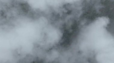 Beyaz kabarık bulutlar arasında temiz hava ve arka planda kötü hava ile gökyüzünde uçan sinematik nefes kesici hava. Cennet konsepti, doğa manzarası 4K