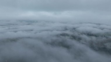 Beyaz kabarık bulutlar arasında temiz hava ve arka planda kötü hava ile gökyüzünde uçan sinematik nefes kesici hava. Cennet konsepti, doğa manzarası 4K