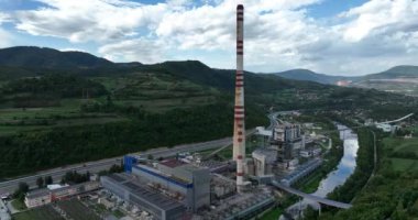 Mavi nehrin yanında iki yüksek soğutmalı kuleli kömür santralinin insansız hava aracı görüntüsü. Bacalardan çıkan duman ve güç üreten türbinlerden çıkan buhar. Yüksek kalite 4k görüntü