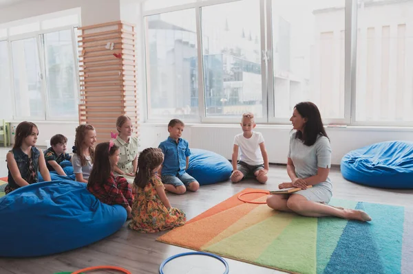 Una Maestra Feliz Sentada Jugando Juegos Manos Con Grupo Niños — Foto de Stock