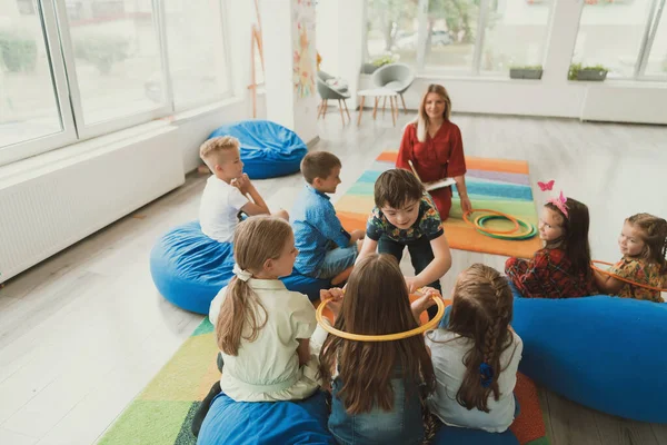 Uma Professora Feliz Sentada Jogando Jogos Mão Com Grupo Crianças — Fotografia de Stock
