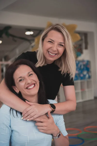 Portret Van Twee Knuffelende Vrouwelijke Leraren Een Kleuterschool Achtergrond Van — Stockfoto