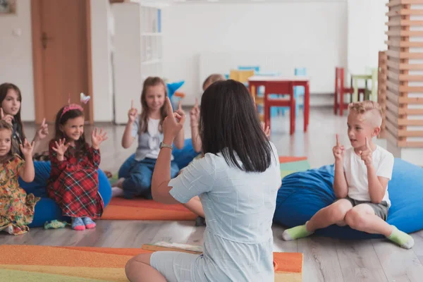 Una Maestra Felice Seduta Che Gioca Con Gruppo Scolaretti — Foto Stock