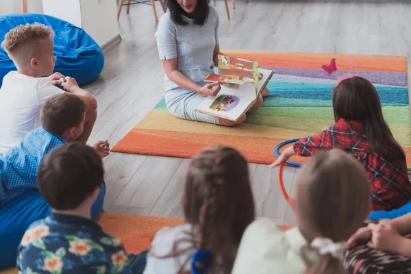 Una Maestra Felice Seduta Che Gioca Con Gruppo Scolaretti — Foto Stock