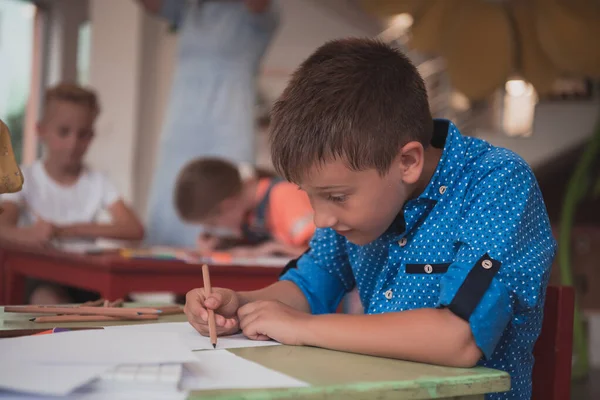 Niedliche Mädchen Und Jungen Sitzen Und Zeichnen Zusammen Den Vorschuleinrichtungen — Stockfoto