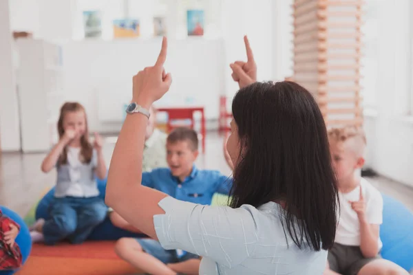 Una Maestra Felice Seduta Che Gioca Con Gruppo Scolaretti — Foto Stock