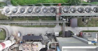 Mavi nehrin yanında iki yüksek soğutmalı kuleli kömür santralinin insansız hava aracı görüntüsü. Bacalardan çıkan duman ve güç üreten türbinlerden çıkan buhar. Yüksek kalite 4k görüntü