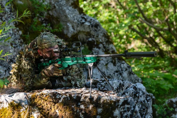 カモフラージュスーツを着た軍人やエアソフトプレーヤーが川を忍び寄り 狙撃銃から側面や標的に狙いを定めている 高品質の写真 — ストック写真