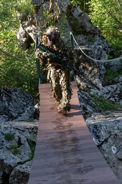 ロープブリッジをこっそりカモフラージュスーツの軍人や航空ソフトプレーヤーと側面またはターゲットに狙撃ライフルから目的 高品質の写真 — ストック写真