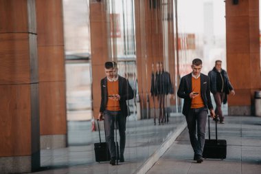 Havaalanı terminaline gidiyorum. Kendine güvenen iş adamı sokaklarda yürüyor, bavulunu çekiyor, kahve içiyor ve akıllı telefondan konuşuyor. Yüksek kalite fotoğraf