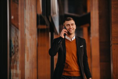 Havaalanı terminaline gidiyorum. Kendine güvenen iş adamı sokaklarda yürüyor, bavulunu çekiyor, kahve içiyor ve akıllı telefondan konuşuyor. Yüksek kalite fotoğraf