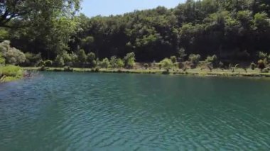 FPV Aerial doğal manzara nehri Una 'da Strbacki Buk şelalesiyle ağaçların altındaki yoğun yeşil ormanda uçma becerisini yakaladı. Yüksek kalite 4k görüntü