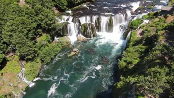 Fpv空中ショット滝Strbackiと自然の風景川Unaで熟練した飛行木の下の濃い緑の森の中にあります 高品質4K映像 — ストック動画
