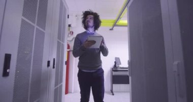 Modern bir sanal veri merkezi süperbilgisayarının sunucu odasında tablet bilgisayar üzerinde çalışan bilişim mühendisi ya da veri bilimci. Günlük kıyafetler giyen hippi, askı koridorunda çalışıyor.