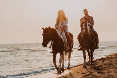 The family spends time with their children while riding horses together on a sandy beach. Selective focus. High quality photo