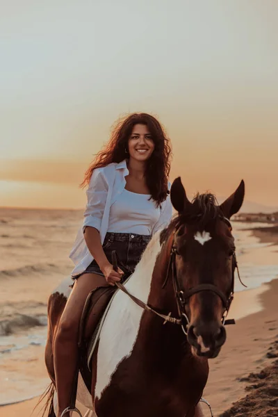 穿着夏装的女人喜欢日落时骑马在美丽的沙滩上 有选择的重点 高质量的照片 — 图库照片