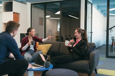 Çok ırklı bir girişim ekibi modern, açık alan çalışma ofisinde toplanıyor. Beyin fırtınası, dizüstü bilgisayarda çalışmak. Hareket bulanıklığı içinde dolaşan bir grup iş arkadaşı. Yüksek kalite fotoğraf