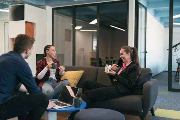 Multiethnic startup business team on meeting in a modern bright open space coworking office. Brainstorming, working on laptop. Group of coworkers walking around in motion blur. High quality photo