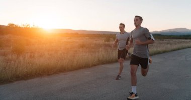 Bir grup genç sporcu şehrin güneşli bir sabahında koşuyor. Yüksek kalite fotoğraf