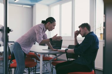 Modern açık uzay ofisinde tartışan duygusal genç meslektaşlar. İş kadını toplantı odasında üzgün asistanına bağırıyor, fotokopi odası, yan görüş. Yüksek kalite fotoğraf