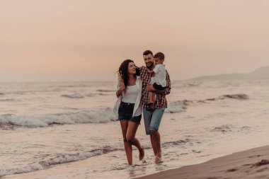Aile, oğluyla kumsalda yürürken tatilin tadını çıkarıyor. Seçici odaklanma. Yüksek kalite fotoğraf